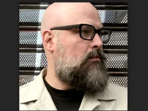 Bald man with glasses against striped background