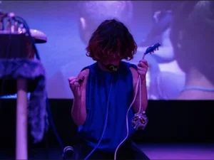 woman performing on stage in a purple light