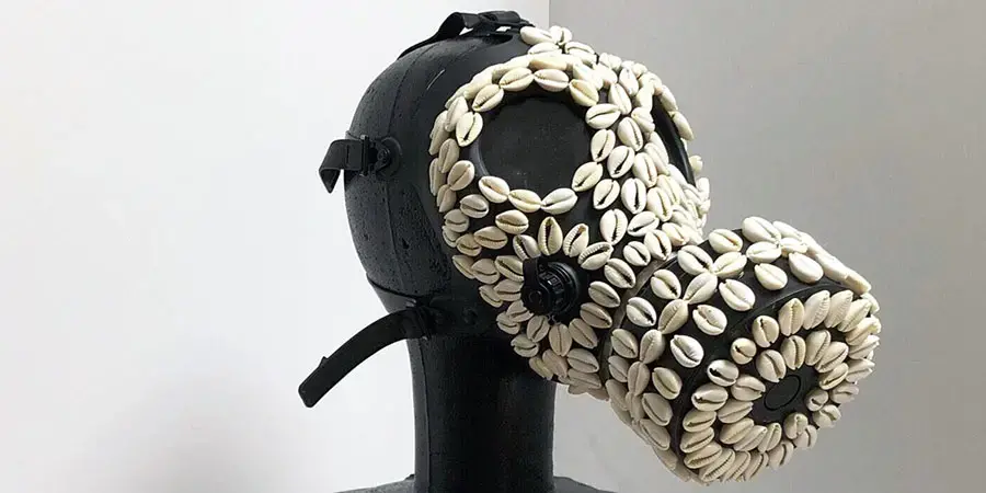 a black sculpture encrusted with white shells